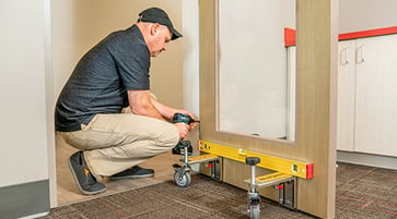 Man kneeling using power drill