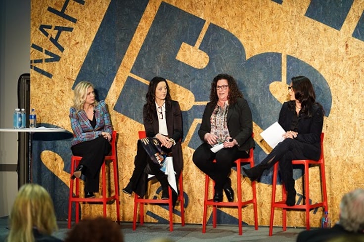 Four women sitting on stage talking